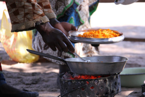 Woman adding pumpkin pulp to the pan to cook a dish of local fish, pumpkin and rape greens in the Barotse floodplain. (Bioversity International/ E.Hermanowicz)
