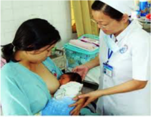 A health care worker provides breastfeeding support to a mother at a local clinic in Vietnam set up by the Alive & Thrive program.